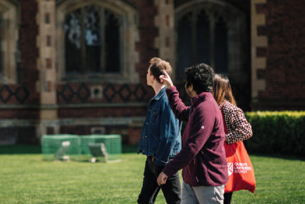 A group of students walk around the quad at Queen's